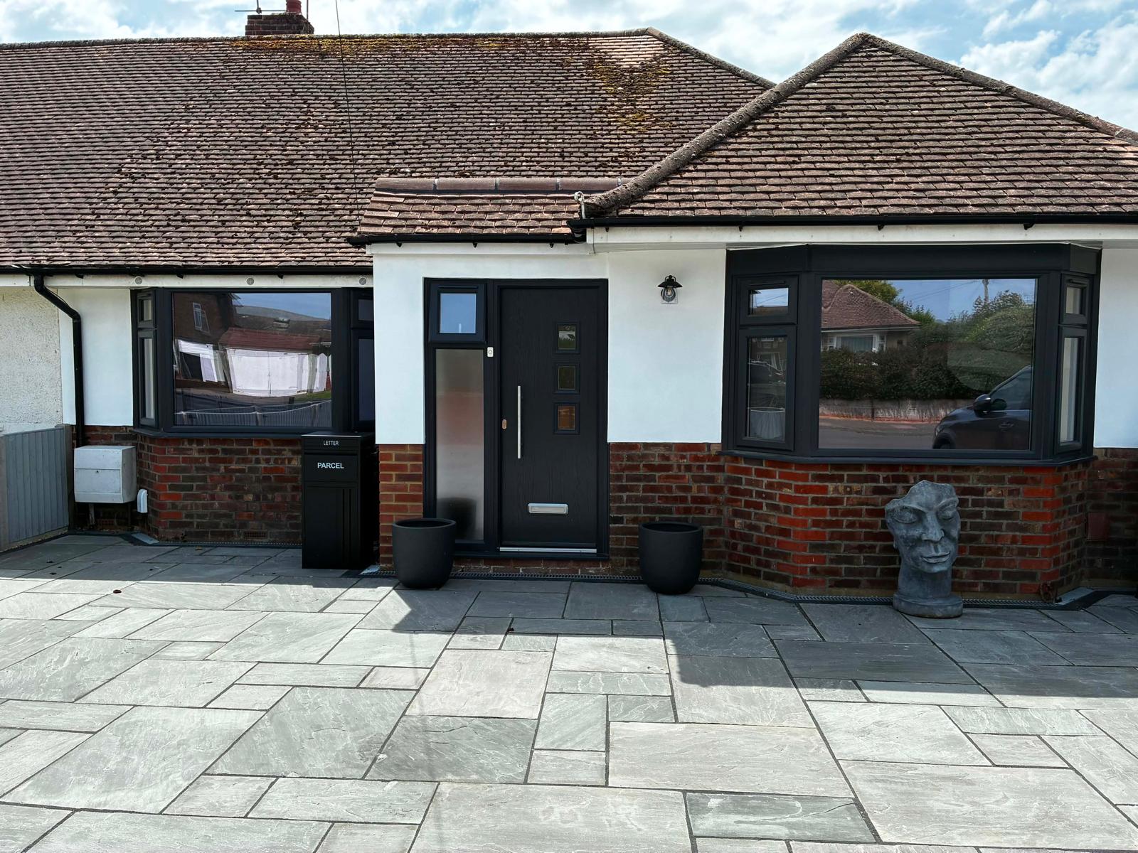 Grey sandstone front driveway laid in front of refurbished bungalow by A Baker Construction West Sussex