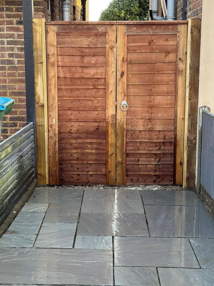 Grey sandstone patio with new timber double gate installed by A Baker Construction West Sussex