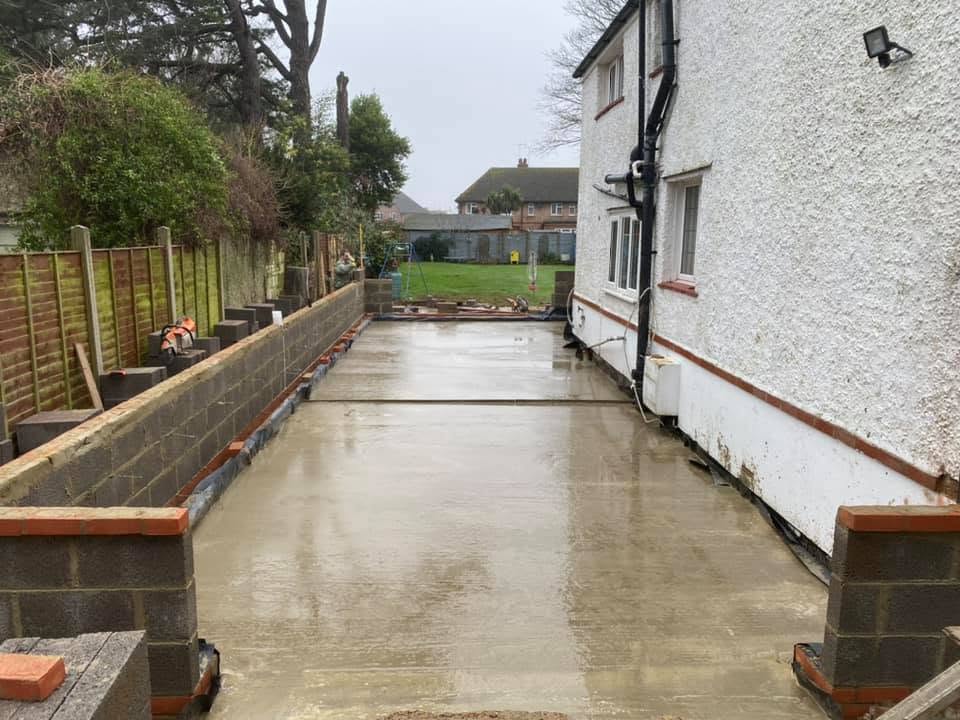 Freshly poured concrete slab with blockwork retaining walls during groundworks by A Baker Construction West Sussex