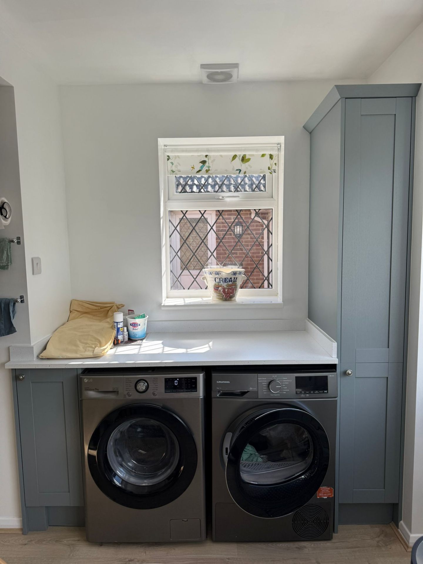 Fitted utility area with grey shaker cabinetry and laundry appliances West Sussex