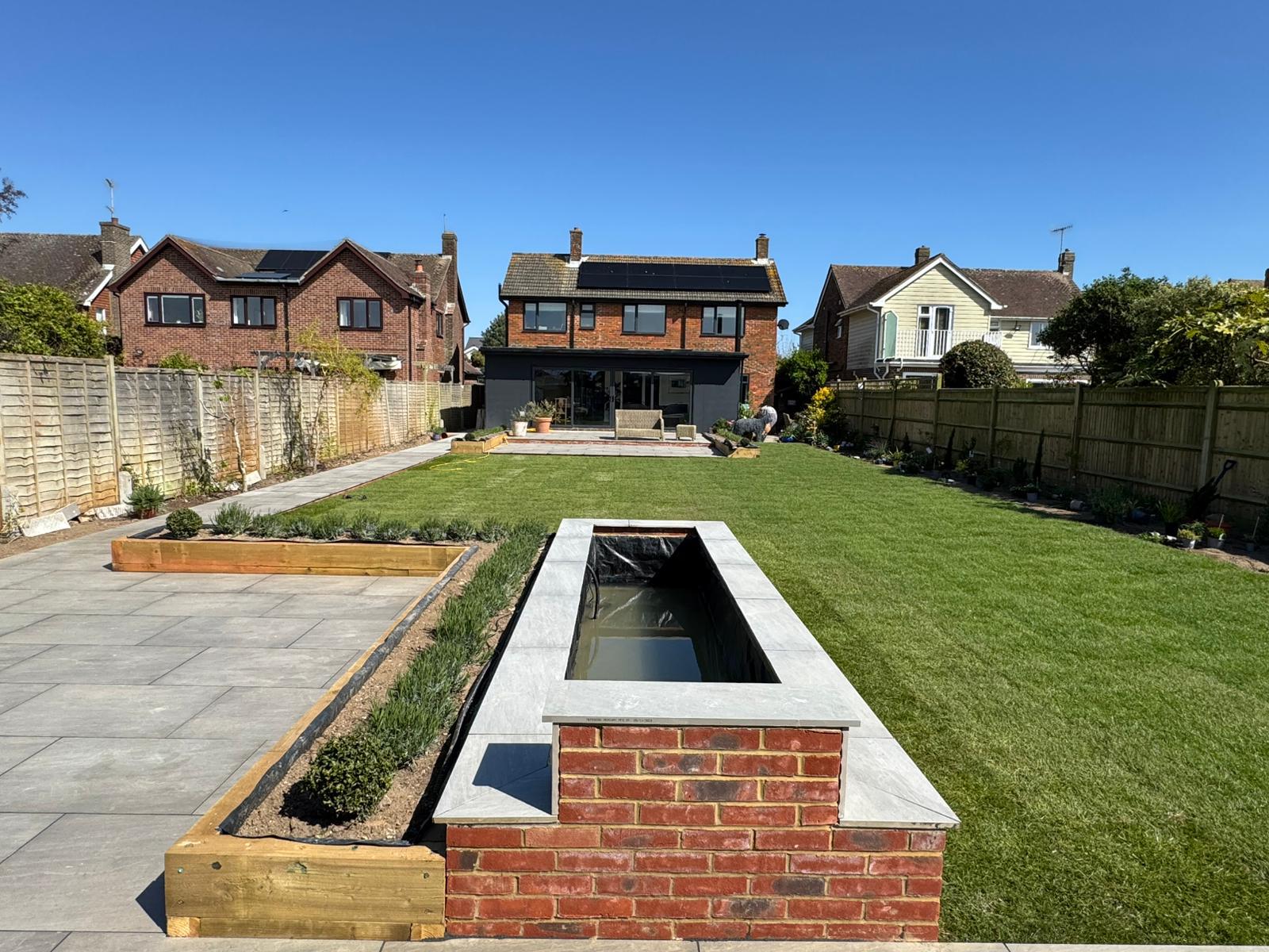 Completed garden makeover with lawn water feature raised beds and patio West Sussex