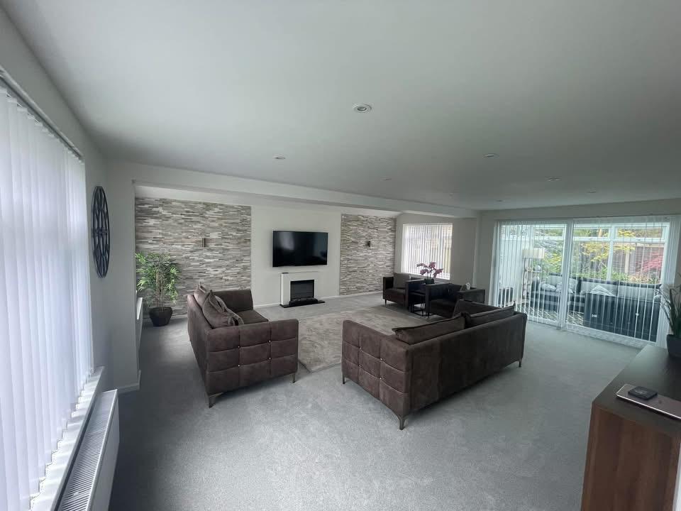 Extended living room interior with feature wall after renovation in West Sussex