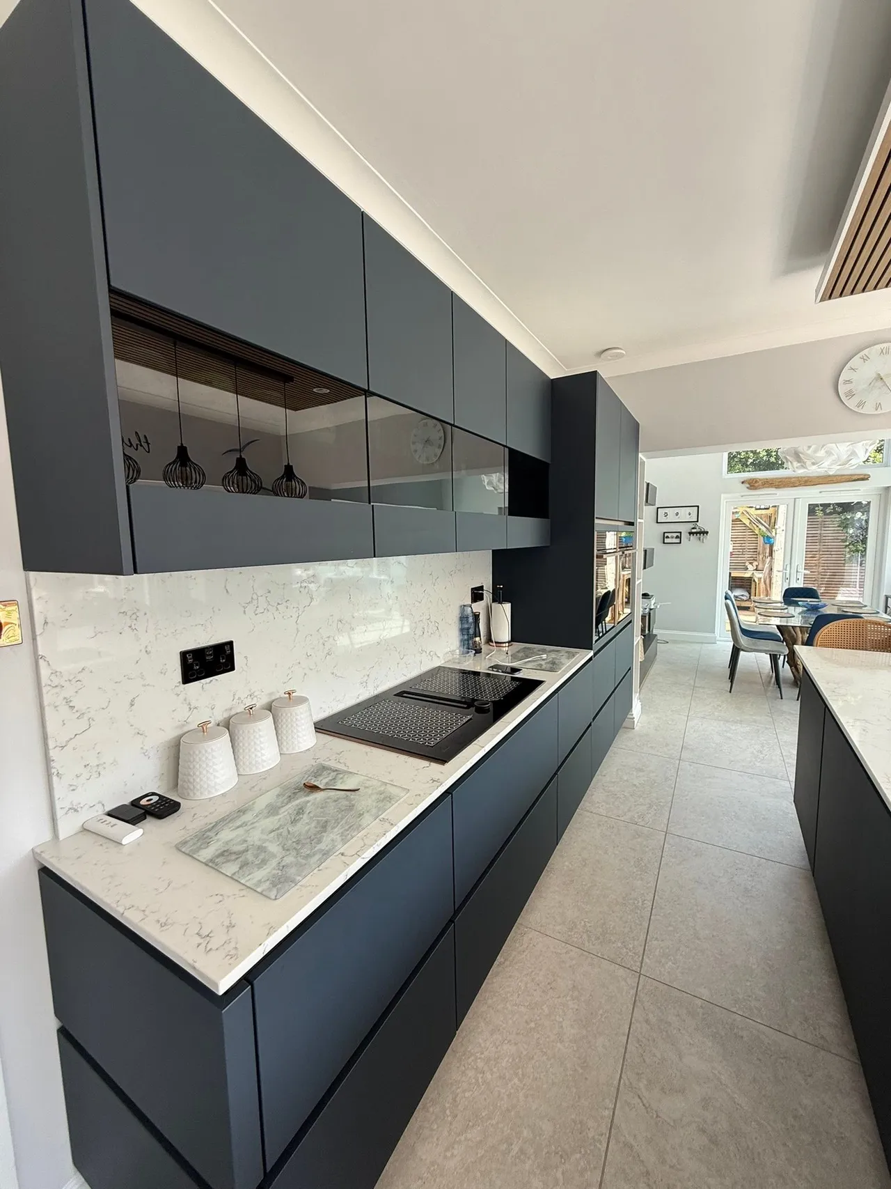 Modern dark handleless kitchen with island and marble worktop West Sussex
