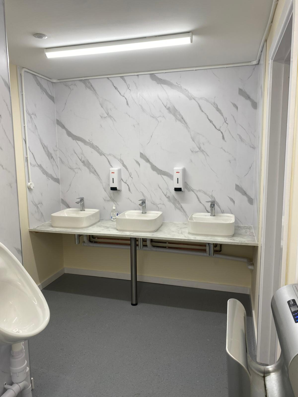 New washroom interior with marble effect walls and sinks Rustington Sports Club West Sussex