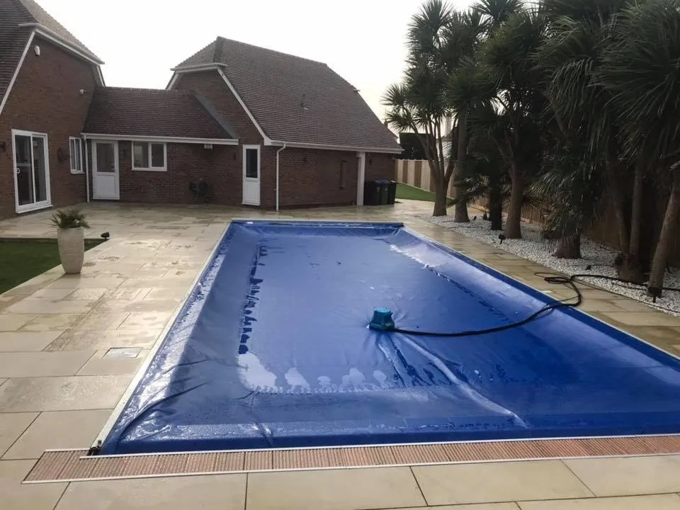 Outdoor swimming pool with sandstone patio completed by A Baker Construction West Sussex